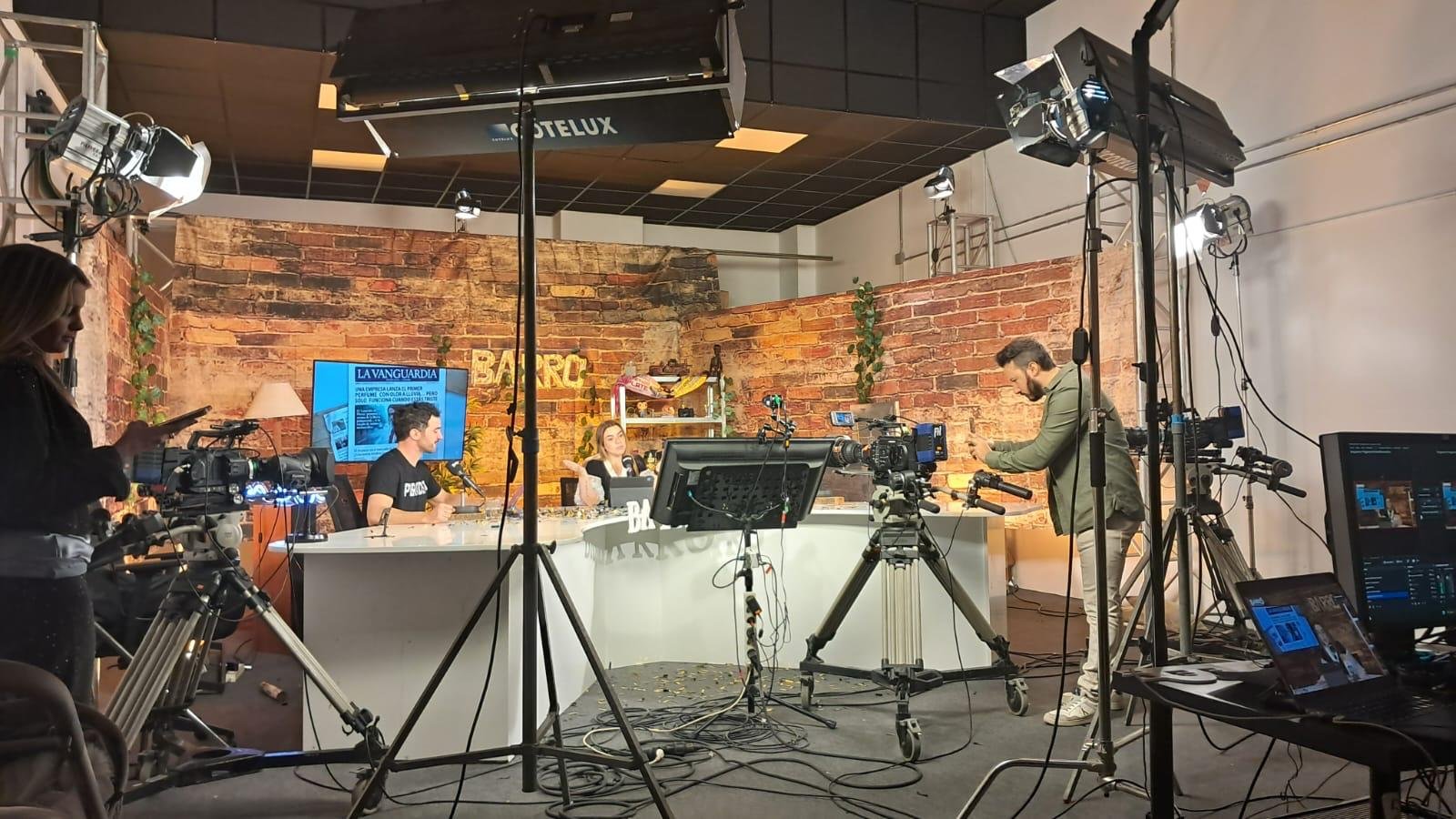 Personas comunicando en el plató profesional de Barro TV, rodeadas de cámaras de televisión e iluminación de estudio